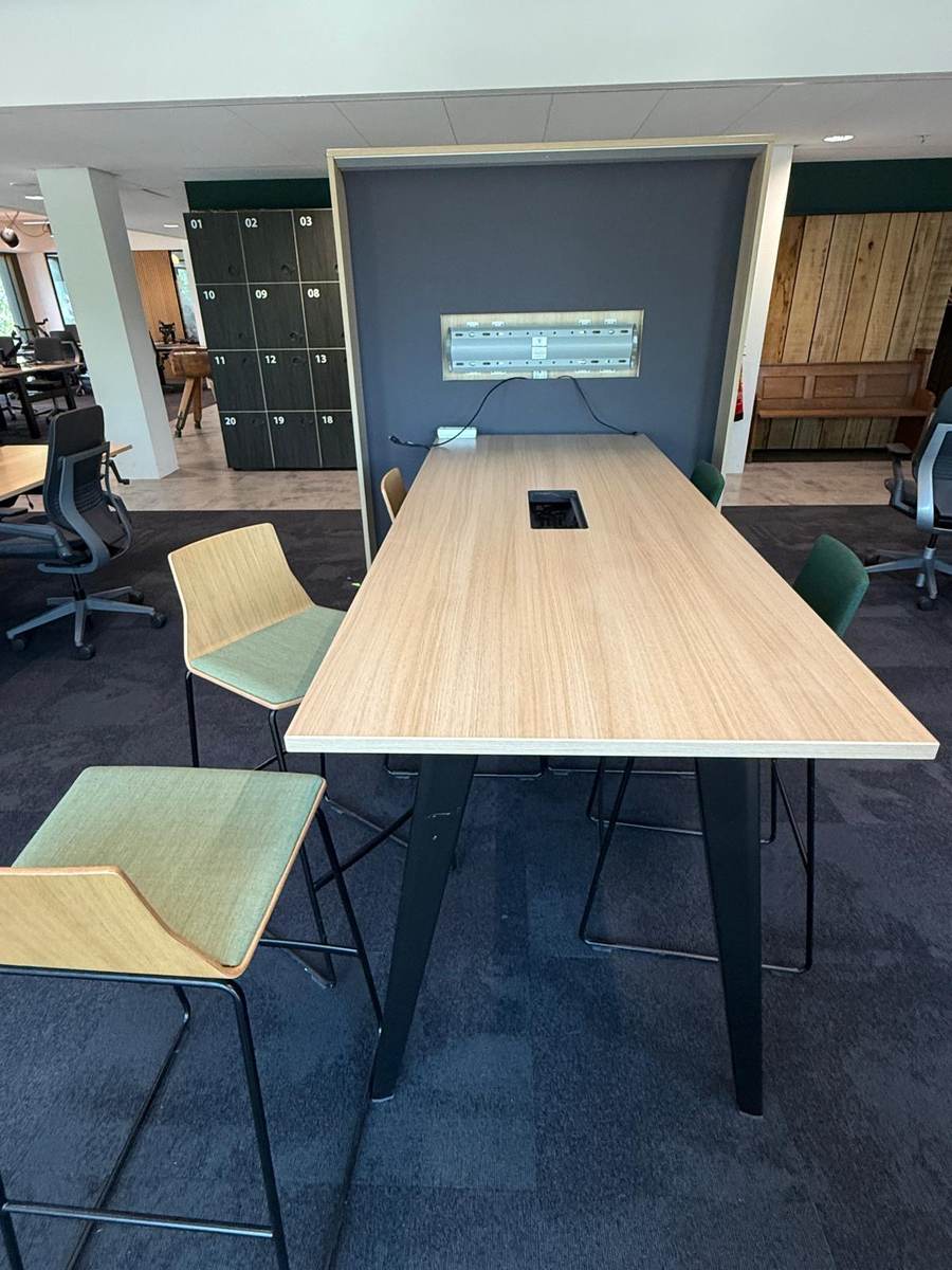 Finished meeting table with chairs and power outlets in the new office