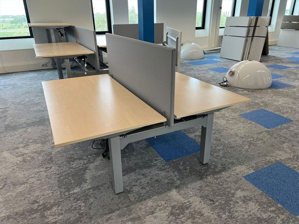 A double bench desk with acoustic screen, set up on the new floor